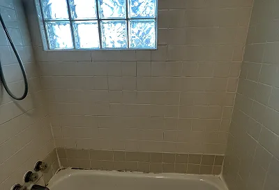 Bathroom after reglazing with restored tub, tiles, and sink
