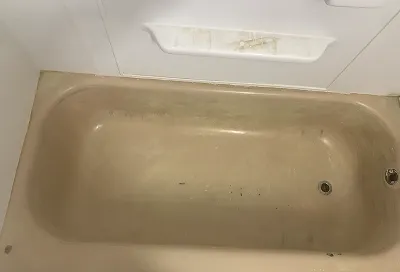 Golden bathtub before reglazing with worn and discolored surface