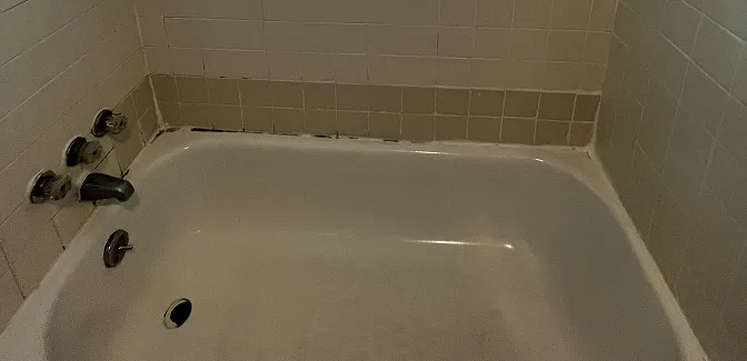 Worn bathroom tiles before reglazing with faded color and stains pgsql Copy code