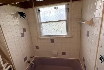 Old wall tiles before refinishing showing discoloration and grout wear