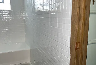 Tile walls before reglazing with cracked and dirty grout lines