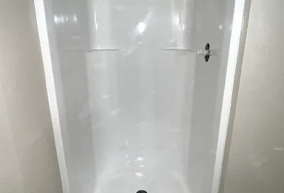 Restored shower stall with bright, durable coating after reglazing