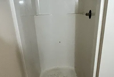 Worn shower stall walls before restoration and reglazing process