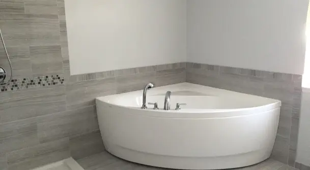 Professional refinishing of a corner bathtub